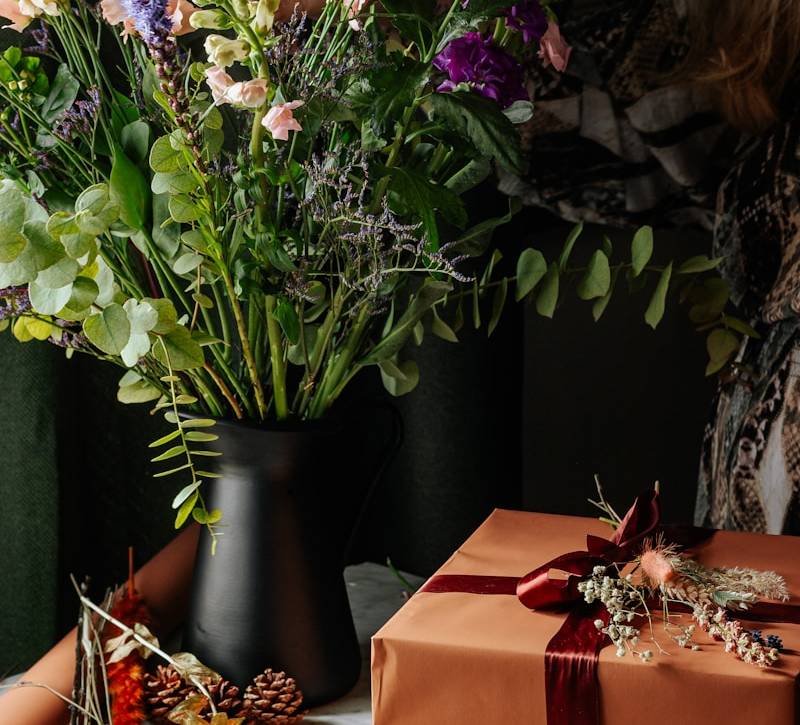 yellow and purple flowers on black vase